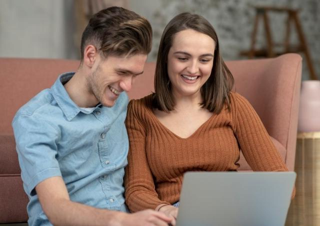 Young couple looking at their laptop.